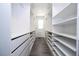 Spacious walk-in closet featuring custom shelving, drawers, and wood flooring at 1097 Trappers Trail Loop, Davenport, FL 33896