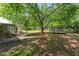 Large backyard with mature trees, patio set, and trampoline - perfect for entertaining and relaxation at 1111 Pinar Dr, Orlando, FL 32825