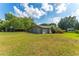 Expansive backyard featuring lush lawn, mature trees, and vibrant flower beds at 1111 Pinar Dr, Orlando, FL 32825