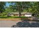 Charming single-story home with lush trees, green lawn, and a two car garage at 1111 Pinar Dr, Orlando, FL 32825