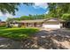 Charming single-story home featuring a manicured lawn, brick driveway, and inviting porch swings at 1111 Pinar Dr, Orlando, FL 32825