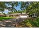 Beautiful single-story home with a well-manicured lawn, mature trees, and a brick driveway at 1111 Pinar Dr, Orlando, FL 32825