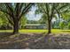 Home's spacious front yard with mature trees at 1111 Pinar Dr, Orlando, FL 32825