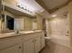 Well lit bathroom featuring a dual sink vanity, large mirror, and shower-tub combo at 12016 Villanova Dr # 102, Orlando, FL 32837