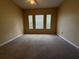 Spacious bedroom featuring neutral colored walls, carpet and three windows with blinds at 12016 Villanova Dr # 102, Orlando, FL 32837