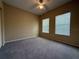 Bedroom featuring two windows for natural light, neutral walls, ceiling fan, and closet at 12016 Villanova Dr # 102, Orlando, FL 32837