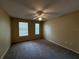 Bedroom featuring carpet floors, ceiling fan, and natural light from two windows at 12016 Villanova Dr # 102, Orlando, FL 32837
