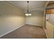 Cozy dining area with neutral walls, chandelier, and view of the kitchen at 12016 Villanova Dr # 102, Orlando, FL 32837