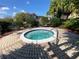 Hot tub surrounded by lush landscape, brick pavers and chairs at 12016 Villanova Dr # 102, Orlando, FL 32837