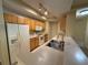Galley kitchen featuring stainless steel sink, white appliances, and wooden cabinets at 12016 Villanova Dr # 102, Orlando, FL 32837