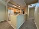 Functional kitchen featuring a breakfast bar, white appliances, and wooden cabinets at 12016 Villanova Dr # 102, Orlando, FL 32837