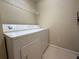 This laundry room features a white washer and dryer and wire shelving unit for storage at 12016 Villanova Dr # 102, Orlando, FL 32837