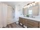 Bright bathroom features a double sink vanity, large mirrors, and a shower-tub combo at 13028 Auburn Cove Ln, Orlando, FL 32828