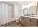 Bright bathroom features a double sink vanity, modern mirrors, and a shower-tub combo at 13028 Auburn Cove Ln, Orlando, FL 32828