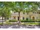 Charming yellow two-story townhome featuring lush landscaping and a welcoming front entrance at 13028 Auburn Cove Ln, Orlando, FL 32828