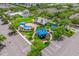 Aerial view of a community playground with colorful structures, seating, and mature trees at 13028 Auburn Cove Ln, Orlando, FL 32828