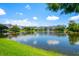 Scenic pond reflects the surrounding buildings and sky, creating a peaceful view from the community at 13028 Auburn Cove Ln, Orlando, FL 32828