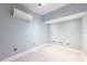 Well lit room with light-colored walls, light floors and an air conditioner on the wall at 13028 Auburn Cove Ln, Orlando, FL 32828
