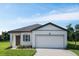 Charming one-story home featuring a two-car garage, manicured lawn, and welcoming front entrance at 1343 Dalkeith Cv, Sanford, FL 32771