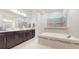 The bathroom features double vanity sinks, a soaking tub, and a tiled walk-in shower at 14124 Dove Hollow Dr, Orlando, FL 32824
