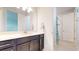 Bathroom with a large mirror, vanity, and a tub-shower with a patterned shower curtain at 14124 Dove Hollow Dr, Orlando, FL 32824