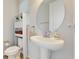 Bright powder room boasts pedestal sink, decorative mirror, and modern fixtures at 14124 Dove Hollow Dr, Orlando, FL 32824