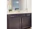 Bathroom featuring a dark vanity, white countertop, and a large mirror at 14124 Dove Hollow Dr, Orlando, FL 32824