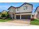 Stunning two-story home with stone accents, a paved driveway, and a three-car garage at 14124 Dove Hollow Dr, Orlando, FL 32824