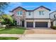 Beautiful two-story home featuring stone accents, manicured lawn, and a brick driveway leading to a three-car garage at 14124 Dove Hollow Dr, Orlando, FL 32824