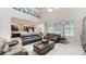 Open-concept living room with dark-stained kitchen cabinetry, a dining nook, and leather furniture at 14124 Dove Hollow Dr, Orlando, FL 32824