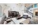 Spacious living room featuring leather furniture, a staircase, and a large television with built-in shelving at 14124 Dove Hollow Dr, Orlando, FL 32824