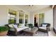 This covered patio has wicker furniture with a ceiling fan and a sliding glass door to the inside at 14124 Dove Hollow Dr, Orlando, FL 32824