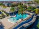 Aerial view of a community pool with palm trees, lounge chairs, and clear blue water at 14124 Dove Hollow Dr, Orlando, FL 32824