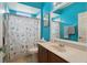 Vibrant bathroom with blue walls, vanity with sink and shower with seashell curtain at 1542 Wescott Loop, Winter Springs, FL 32708
