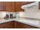 Close-up of kitchen countertop featuring range, appliances, and wooden cabinets at 1542 Wescott Loop, Winter Springs, FL 32708