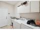 Functional laundry room featuring a washer, dryer and tiled floors and backsplash at 1542 Wescott Loop, Winter Springs, FL 32708