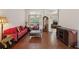 Comfortable living room features hardwood floors, bright windows and a red sofa at 1542 Wescott Loop, Winter Springs, FL 32708