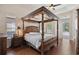 Elegant main bedroom with a four-poster bed, hardwood floors, and access to the lanai through sliding glass doors at 1542 Wescott Loop, Winter Springs, FL 32708