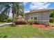 Landscaped yard with green grass, a palm tree and a neatly maintained garden bed at 1542 Wescott Loop, Winter Springs, FL 32708
