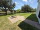 Backyard features a brick fire pit, green lawn, and a tranquil lake at 1546 Water Elm Ct, Orlando, FL 32825