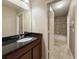 Bathroom featuring a dark vanity with granite counters and a mirror at 1546 Water Elm Ct, Orlando, FL 32825