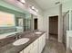 Bright bathroom with double sinks, granite countertops, soaking tub, and separate glass shower at 1546 Water Elm Ct, Orlando, FL 32825