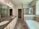 Bathroom featuring double vanity, soaking tub, walk-in shower, and a walk-in closet at 1546 Water Elm Ct, Orlando, FL 32825