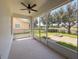 Covered patio looking out to a green backyard with a brick firepit and lake at 1546 Water Elm Ct, Orlando, FL 32825