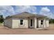 New home construction exterior featuring a gray roof, block walls, and white trim windows at 1635 Cane Bamboo Drive, St Cloud, FL 34771