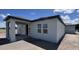 Exterior elevation showcasing a covered porch, windows, and neutral color scheme at 1635 Cane Bamboo Drive, St Cloud, FL 34771