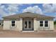 New home construction exterior featuring a gray roof, block walls, white trim windows, and a covered entryway at 1635 Cane Bamboo Drive, St Cloud, FL 34771