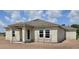 New home construction exterior featuring a gray roof, block walls, white trim windows, and covered back porch at 1635 Cane Bamboo Drive, St Cloud, FL 34771