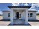Rear of home showcasing a covered entrance with windows and neutral color scheme at 1635 Cane Bamboo Drive, St Cloud, FL 34771