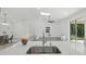 An airy kitchen features stainless steel appliances, eat-in island, and open access to the living room at 17 Cypress Run, Haines City, FL 33844